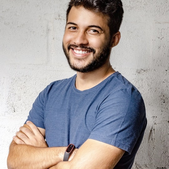 Side profile of a man smiling to the camera with crossed arms