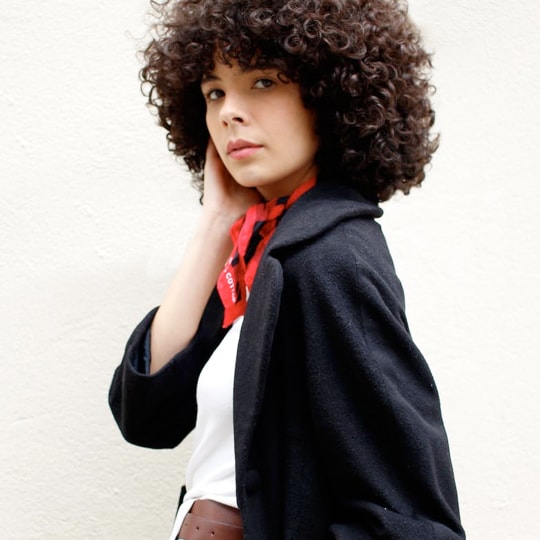 Side profile of a woman with a black jacket and red scarf